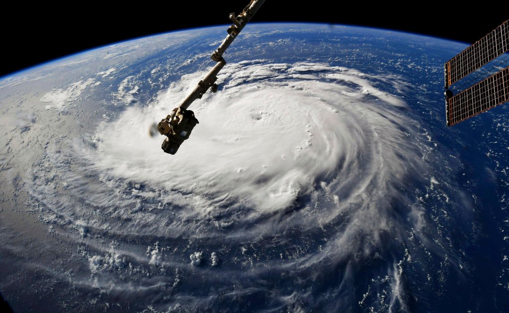 Navy warships sail out of Norfolk while Air Force planes fly into the heart of the hurricane